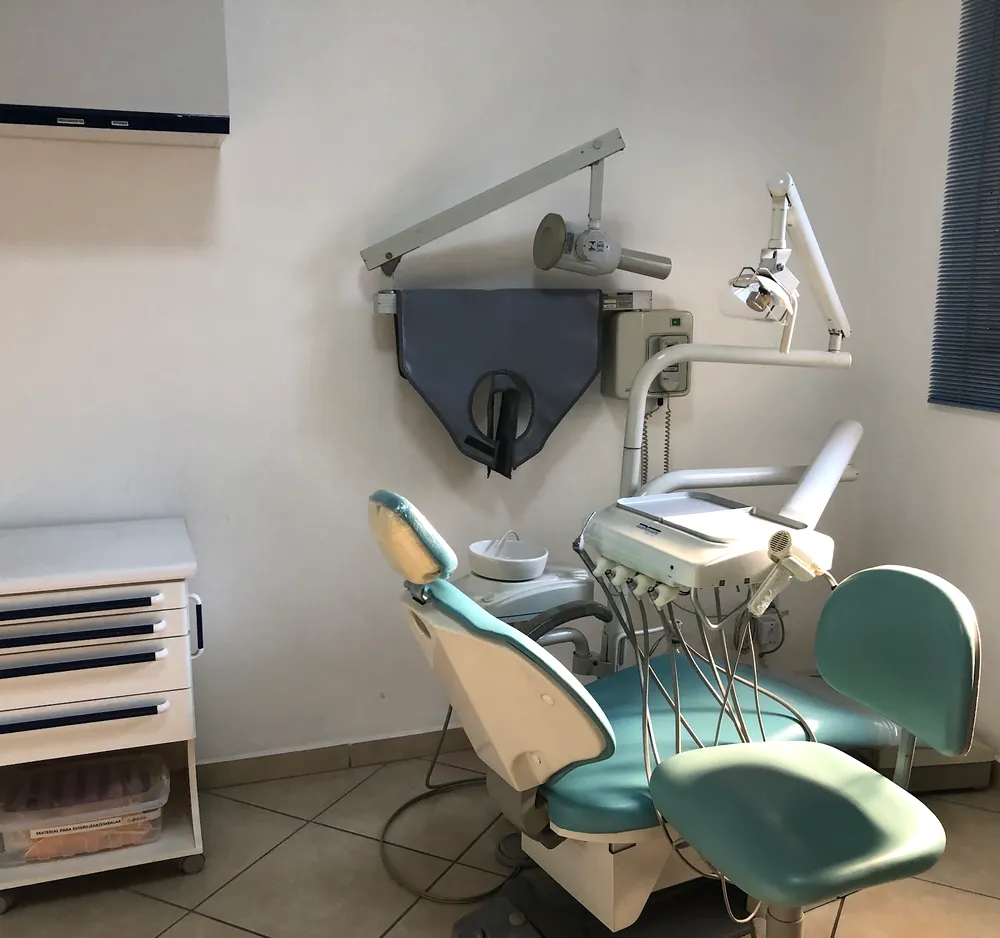 Consultório com cadeira odontológica verde-água