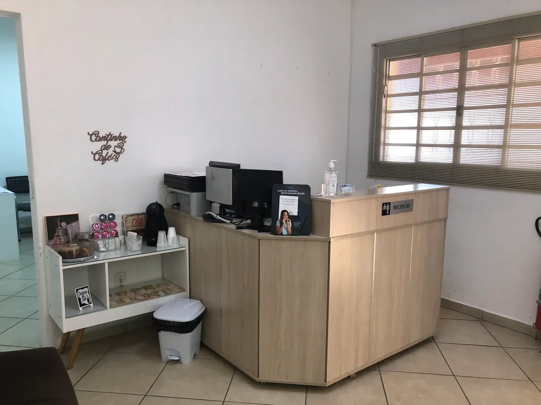 Recepção da CEPRO Odonto com balcão de madeira e cantinho do café